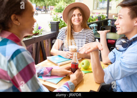 Les élèves appréciant le déjeuner dans le café en plein air Banque D'Images