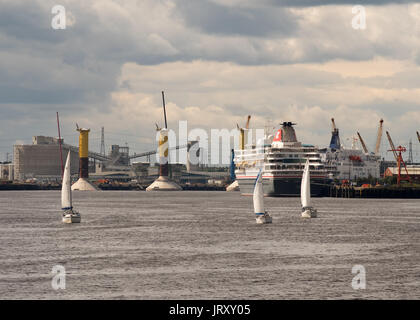 Trois yachts voile dans la rivière Tyne avec Fred Olsen cruise navire amarré à l'arrière-plan. Shields, England, UK Banque D'Images