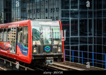 Le Docklands Light Railway train passe devant un immeuble de bureaux sur l'Isle of Dogs, London, E14. Banque D'Images