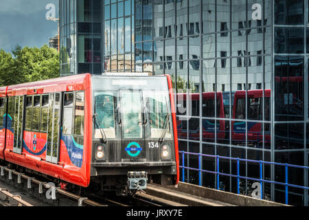 Le Docklands Light Railway train passe devant un immeuble de bureaux sur l'Isle of Dogs, London, E14. Banque D'Images