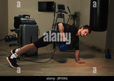 L'homme athlétique Fitness stimulation musculaire électrique en fonction de la levée de poids dans une salle de sport Banque D'Images