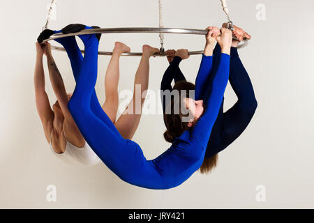 Trio de jeune femme faisant des tours acrobatiques som lustre aérienne Banque D'Images