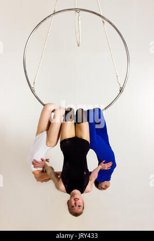 Trio de jeune femme faisant des tours acrobatiques som lustre aérienne Banque D'Images