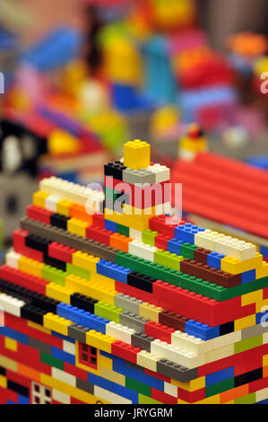 Diverses pièces de lego de couleurs vives à côté d'un bâtiment lego. jouets pour enfants et jeux de construction pour construire l'apprentissage. la construction et l'architecture. Banque D'Images