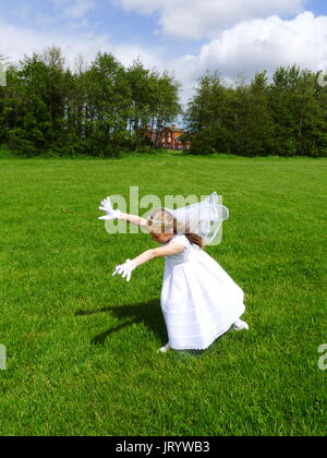 Première Communion fille dans sa robe blanche et voile faisant la roue kids park, joyeux, joie, bonheur, concept, sans souci de la liberté, de jour Banque D'Images