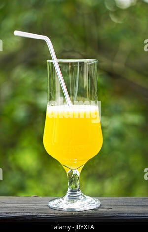 Des jus d'ananas dans grand verre avec de la paille à l'extérieur Banque D'Images