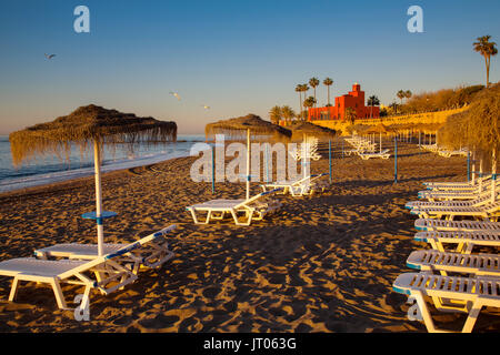 Des hamacs de la plage au lever du soleil. Bil-Bil château construit en style néo-arabes en 1934, à Benalmadena. La province de Malaga Costa del Sol. Andalousie Le sud de l'Espagne, Europ Banque D'Images