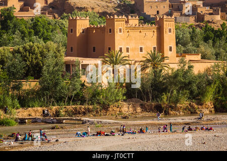 Les femmes et les enfants à laver les vêtements dans la rivière, Kelaat M'Gouna, la vallée des roses. Le Maroc, Maghreb, Afrique du Nord Banque D'Images