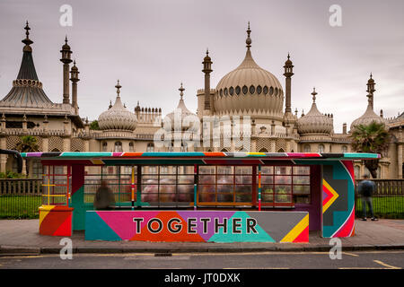 Personnes en attente d'un bus à l'intérieur d'un abri bus peintes de couleurs vives, Brighton, Sussex, UK Banque D'Images