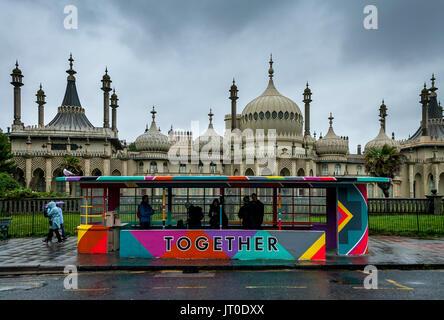 Personnes en attente d'un bus à l'intérieur d'un abri bus peintes de couleurs vives, Brighton, Sussex, UK Banque D'Images