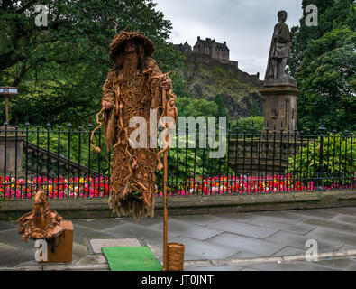 Edinburgh, Ecosse, Royaume-Uni. Le 6 août 2017. Un artiste de rue pendant le Festival Fringe d'effectue un acte de lévitation habillé comme Gandalf devant le Château d'Édimbourg et de Princes Street Gardens sur une après-midi d'août Banque D'Images