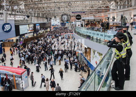 Londres, Royaume-Uni. 07Th Aug, 2017. La police des transports avec un Taser regarder depuis la mezzanine comme foules atteindre un pic dans le grand hall après 6 heures - dix plates-formes sont fermées à la gare de Waterloo pour tout le mois d'août pour une mise à niveau de plates-formes. Crédit : Guy Bell/Alamy Live News Banque D'Images