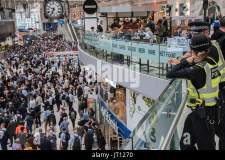 Londres, Royaume-Uni. 07Th Aug, 2017. La police des transports avec un Taser regarder depuis la mezzanine comme foules atteindre un pic dans le grand hall après 6 heures - dix plates-formes sont fermées à la gare de Waterloo pour tout le mois d'août pour une mise à niveau de plates-formes. Crédit : Guy Bell/Alamy Live News Banque D'Images