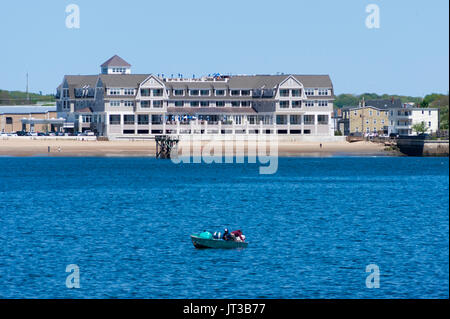 Les pêcheurs dans un petit bateau de pêche dans le port de Gloucester, avec le front de Gloucester dans l'arrière-plan. Cape Ann, Massachusetts. Banque D'Images