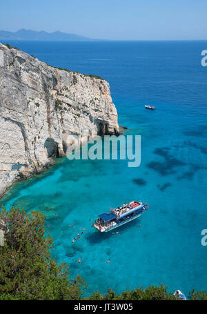 Le ferry pour passagers Spartacus amarré au large de la côte de Zakynthos, avec des vacanciers qui nagent autour, dans la mer Ionienne calme Banque D'Images