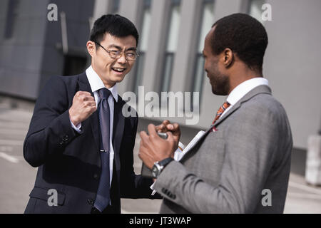 Young smiling businessmen in formalwear multiethnique, célébrons les succès de la réunion de l'équipe d'affaires Banque D'Images