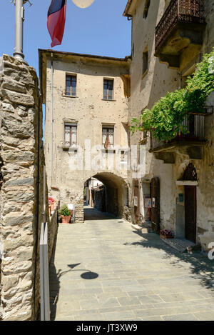 Maisons anciennes avec passage voûté sur antique road dans le village médiéval de montagne, tourné par un beau jour d'été à Bard, de la vallée d'aoste, Italie Banque D'Images