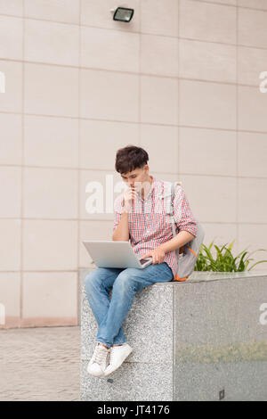 Male student working on laptop in university Banque D'Images