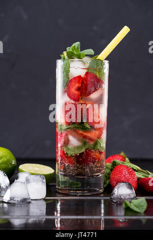 Verre de limonade aux fraises avec des cubes de glace, d'un bar à cocktails concept d'arrière-plan Banque D'Images