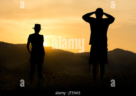 Silhouette d'un couple romantique coucher de soleil sur la colline Banque D'Images