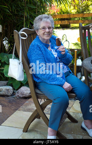 Older woman eating ice lolly outdoors.Personnes âgées, Banque D'Images