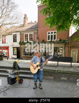 Man wearing blue shirt et jeans en denim, jouer à la guitare électrique et le chant, arts de la rue dans la ville de York, en Angleterre, Banque D'Images