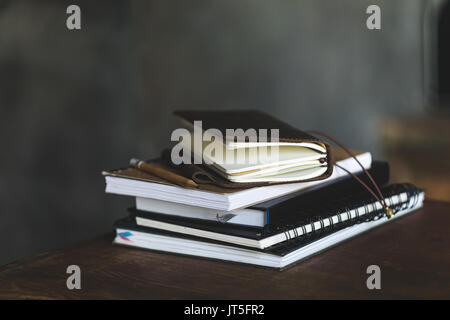 Close-up view of stacked notebooks et crayon sur tableau noir Banque D'Images