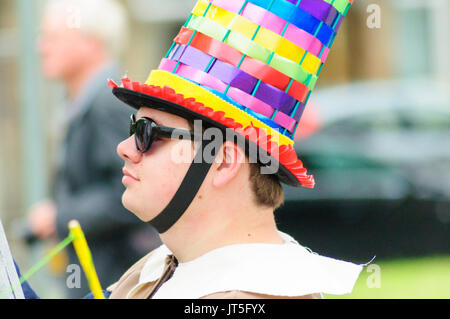 Homme portant un chapeau et des lunettes colorés célébrant tourné Sma dans la parade de jour voyageant à travers les rues de Paisley, Scotland Banque D'Images