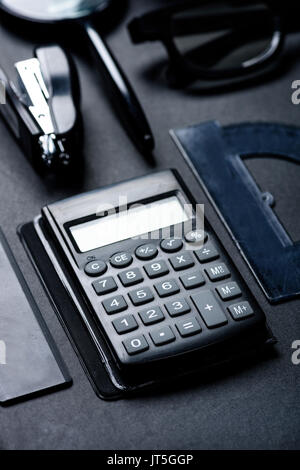 Calculatrice avec divers ustensiles bureau mock-up isolated on black Banque D'Images