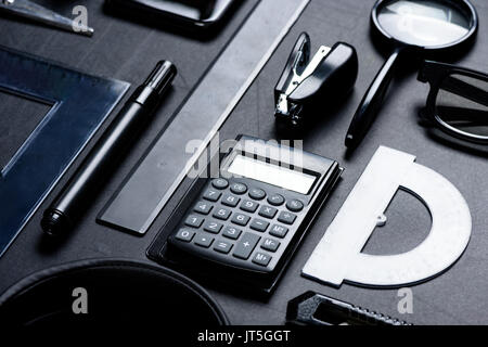 Calculatrice avec divers ustensiles bureau mock-up isolated on black Banque D'Images