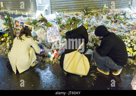 3 personnes s'agenouilla en deuil. Hommage spontané à des victimes des attaques terroristes à Paris le 13 novembre 2015. Banque D'Images