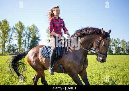 Happy young woman galoper academie sur terrain et profiter de sentiment de liberté Banque D'Images