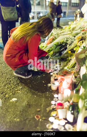 Hommage spontané à des victimes des attentats à Paris le 13 novembre 2015 : une femme est une bougie d'éclairage Banque D'Images