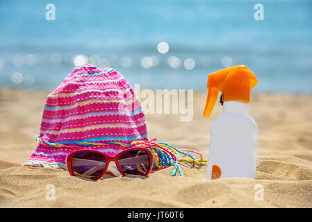 Bouteille de crème solaire sur la plage de sable. Banque D'Images