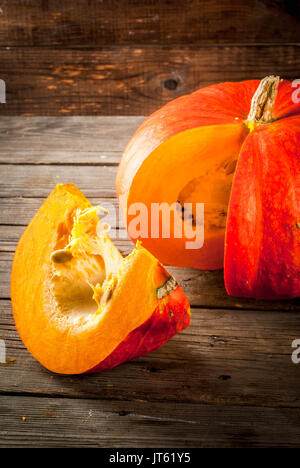 Les légumes d'automne, la récolte. Les matières organiques fraîches orange citrouille sur une vieille table en bois rustique, ensemble et les couper en morceaux. Copy space Banque D'Images