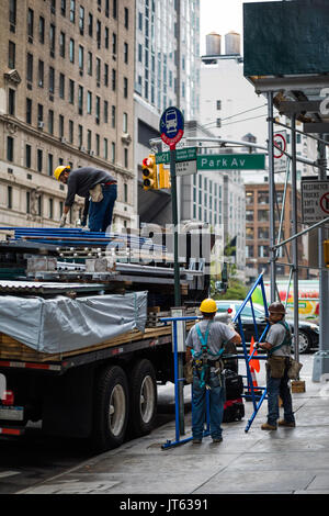 NEW YORK, USA - Le 13 octobre 2016. Peu de gens avec chariot de déchargement des matériaux de construction comme d'échafaudages et d'autre structure sur la 5e Avenue, New York. Banque D'Images