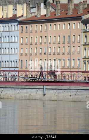 Lyon (sud-est de la France) : l'immobilier, les bâtiments le long du quais de Saône passerelle, avec une femme qui a une marche avec son chien sur la passerelle de la Banque D'Images