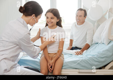 Fille positive joyeuse d'être vérifié par le médecin Banque D'Images