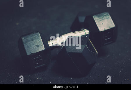 En caoutchouc noir et acier poids utilisés pour l'entraînement à l'exercice dans la salle de sport, pour construire le muscle pour la santé. Image style sombre,idéal pour les graphiques de remise en forme Banque D'Images
