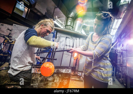 Deux artistes en verre soufflé la finition d'une belle pièce. Banque D'Images