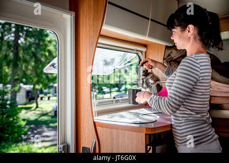 La cuisine femme dans le camping-car, Camping de l'intérieur. Vacances famille vacances, voyages voyage en camping-car, caravane location de vacances. Banque D'Images