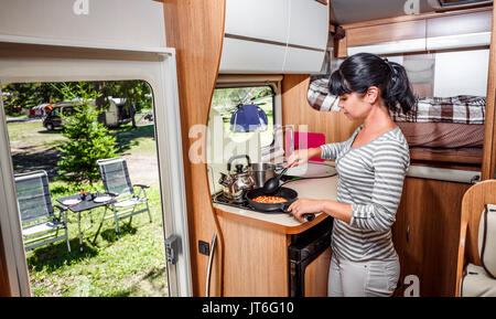 La cuisine femme dans le camping-car, Camping de l'intérieur. Vacances famille vacances, voyages voyage en camping-car, caravane location de vacances. Banque D'Images