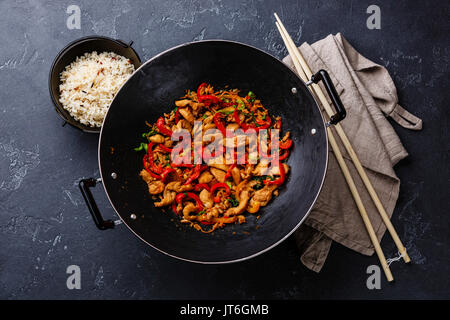 Faire revenir avec la viande de poulet et légumes au wok casserole sur fond noir en sombre Banque D'Images