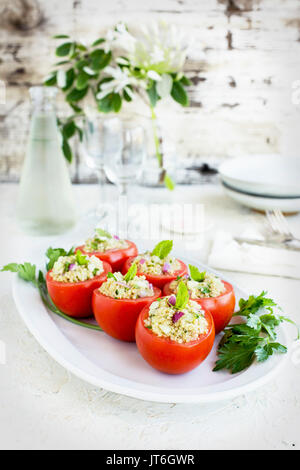 Taboulé Quinoa tomates farcies servies avec du vin blanc. Photographié sur un fond de plâtre blanc. Banque D'Images