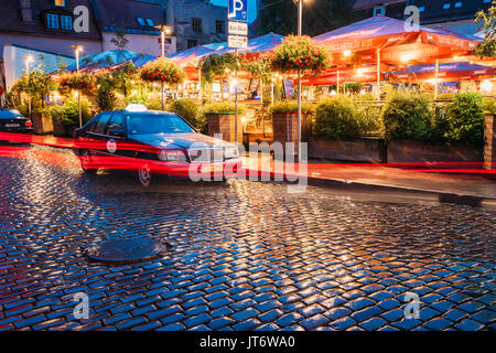 Riga, Lettonie - Juillet 3, 2016 : Taxi Voiture Mercedes-Benz W140 Clients attendre près de Open Air Lieu de loisirs centre de loisirs Egle en soirée ou la nuit Illuminat Banque D'Images