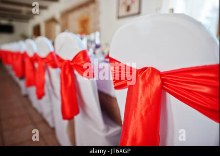 Magnifiquement décorées avec des chaises arcs rouge noué sur eux. Banque D'Images