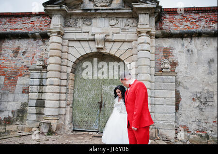 Superbe couple de mariage à côté des anciens portes d'un château. Banque D'Images