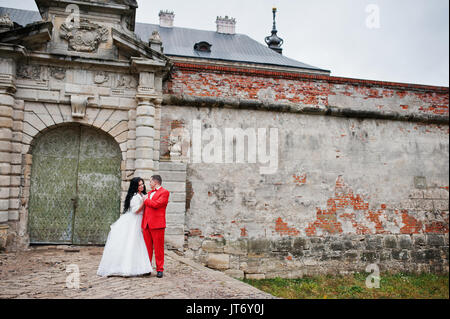 Superbe couple de mariage à côté des anciens portes d'un château. Banque D'Images