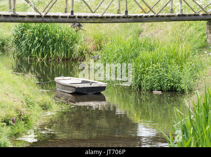 Une vieille barque en bois amarré dans un petit ruisseau. Banque D'Images