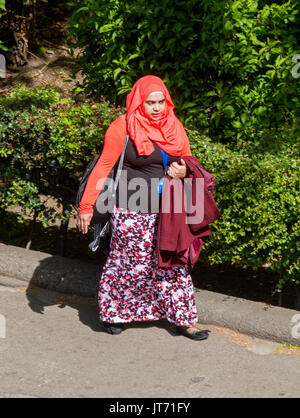 Jeune femme musulmane, le port du foulard coloré et marcher le long de la jupe dans la rue ville de York, Angleterre Banque D'Images